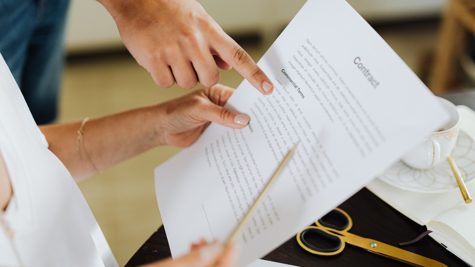 Hands reviewing business documents during diligence