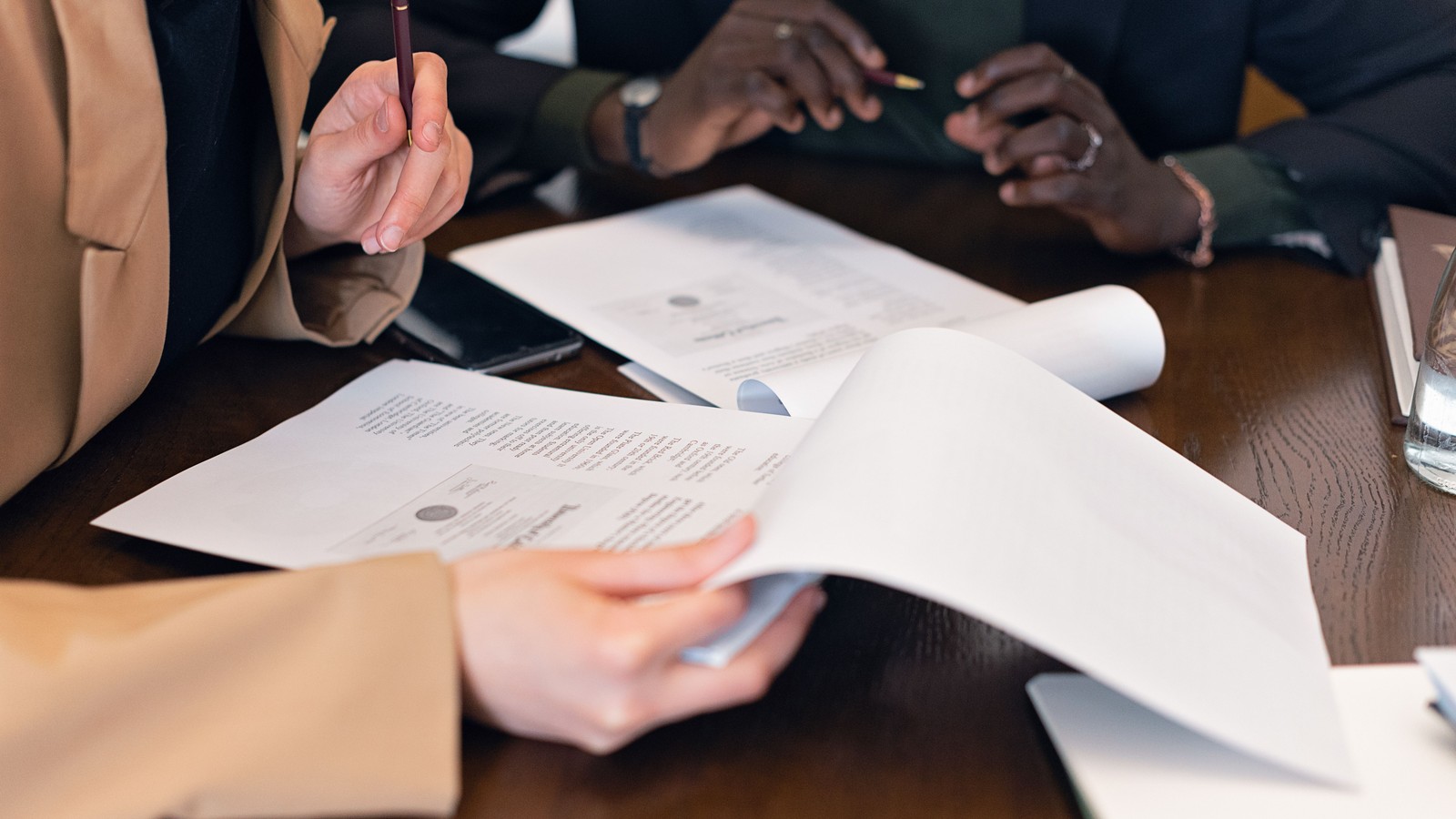 Advisers reviewing business documents for an acquisition checklist