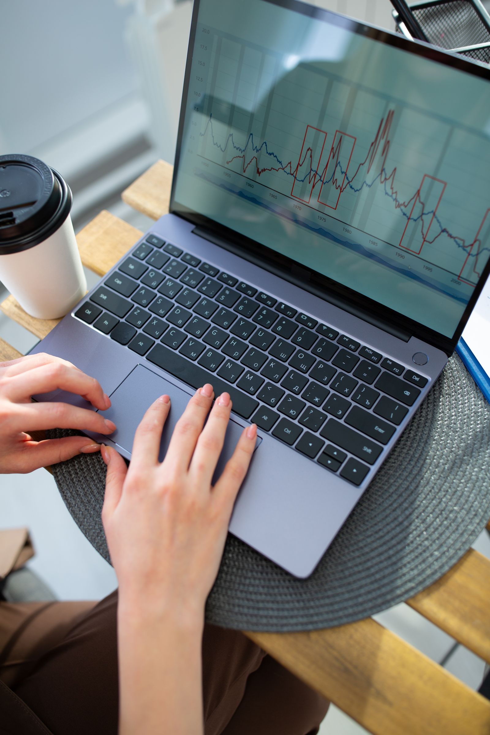 Hands using a laptop with a data chart