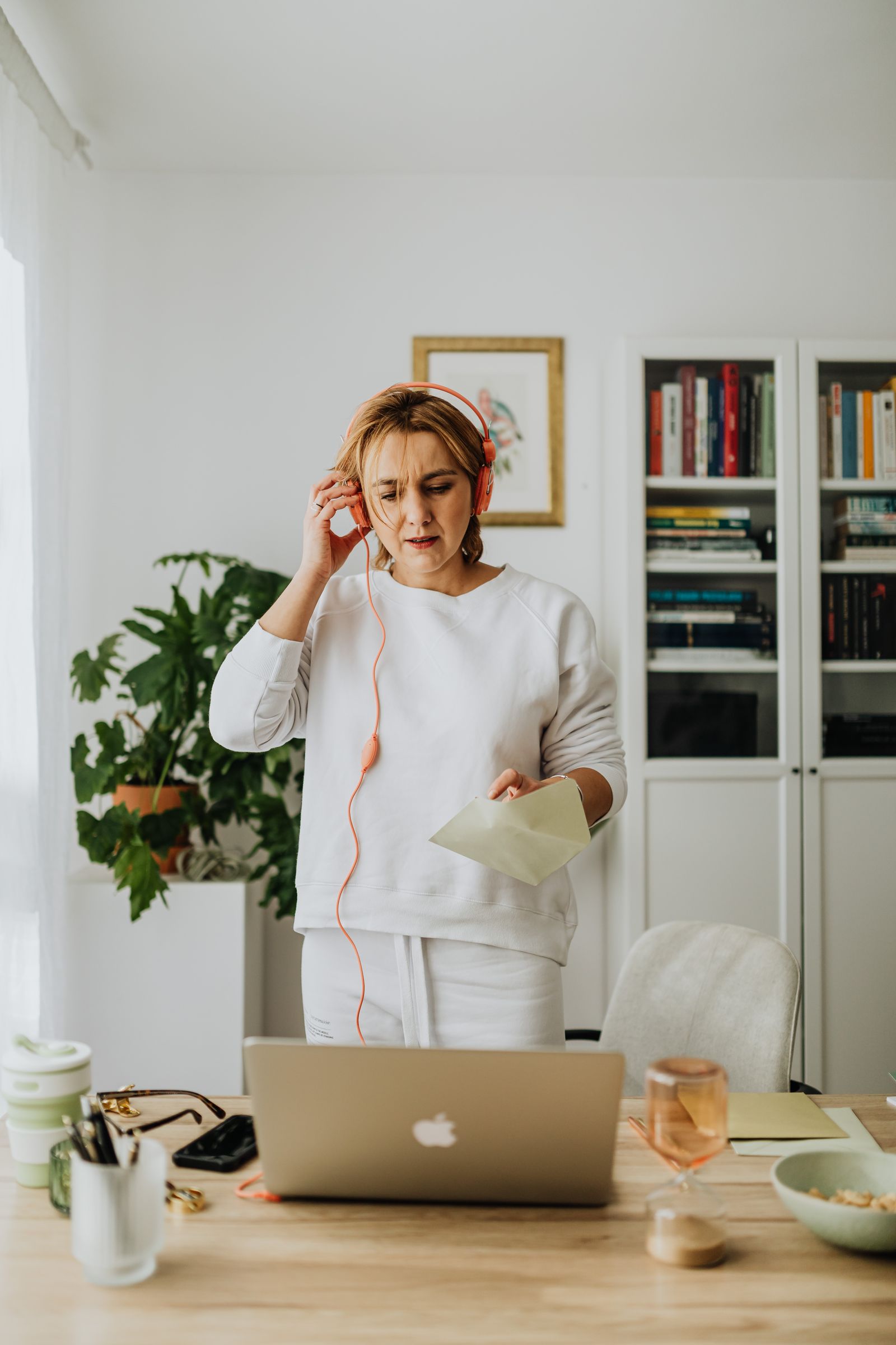 Woman listening through headphones while using a laptop