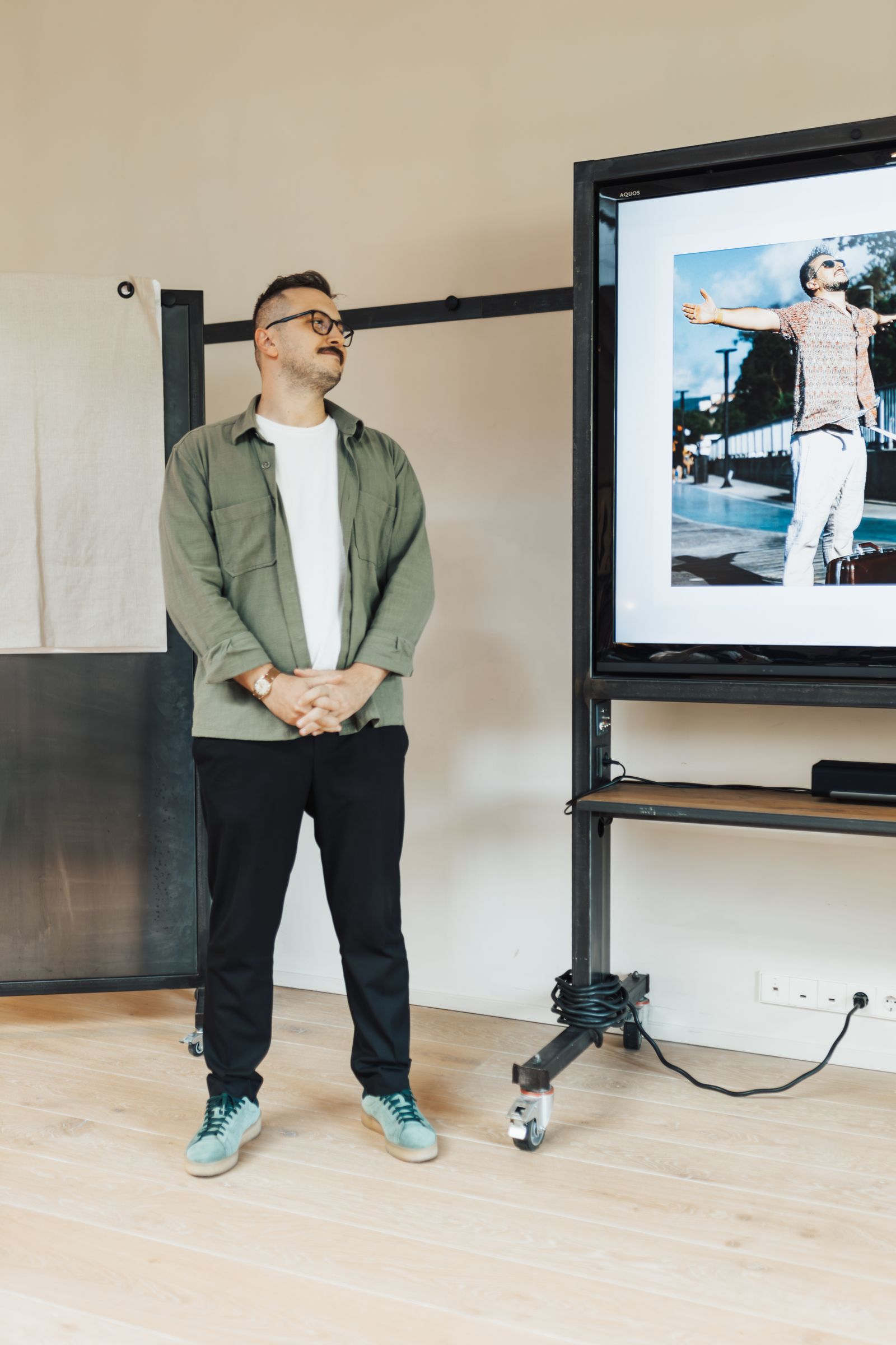 Presenter beside a meeting-room screen